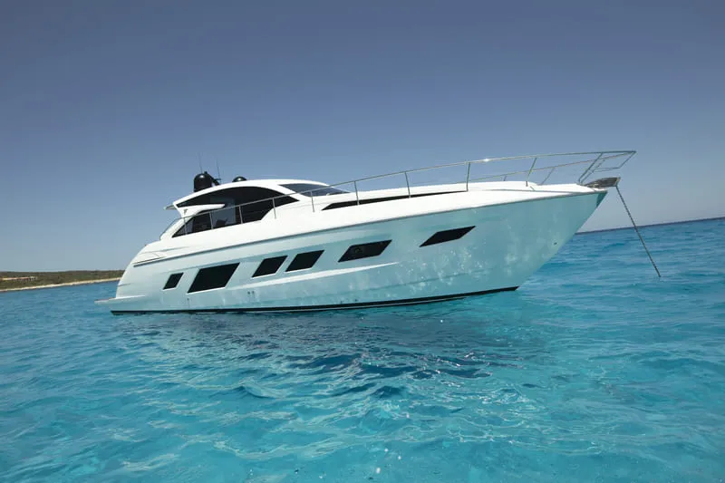 Yacht anchored at a bay in Mallorca. Turquoise sea. White spacious new boat for rental.