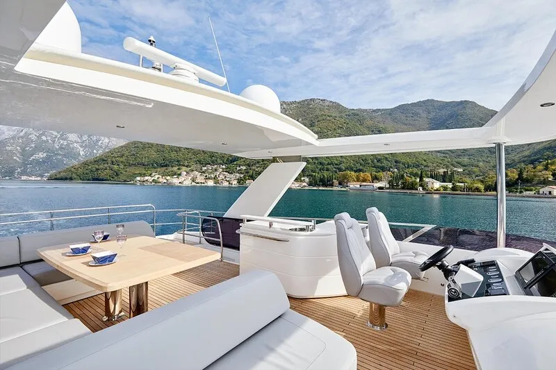 Flybridge of a yacht in charter in Mallorca. Snny day, teak floor and white sofa.