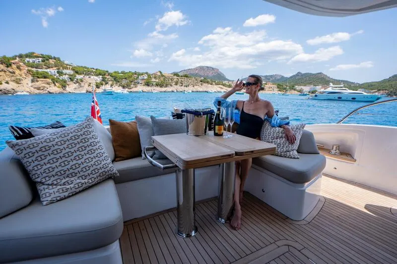 Yacht in charter in Mallorca anchored at a bay in Mallorca. Boat has a spacious flybridge and a hydraulic bathing platform.