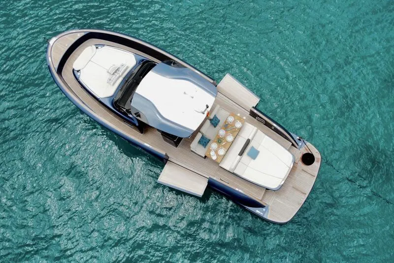 boot mieten mallorca. Neue Yacht vor Anker in einer Bucht auf Mallorca. Geräumiges Layout. Sonnenliegen in Beige und blauer Rumpf.