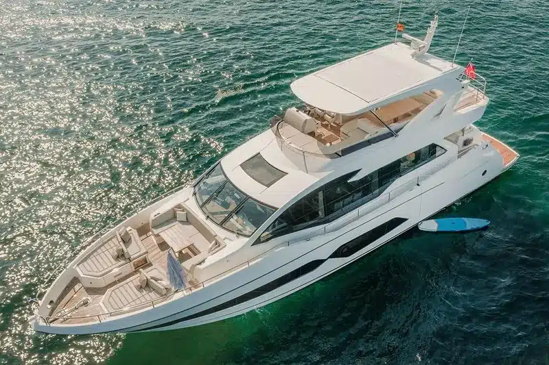 yacht in charter anchored at a bay in Mallorca. New white boat with a Flybridge. Sunny day.