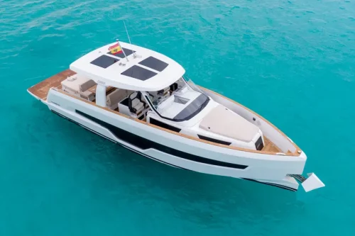 yacht in charter in Mallorca. New white boat anchored in a bay with turquoise water.