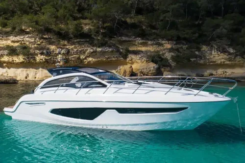 Yacht in charter in Mallorca anchored at a bay. Sunny day and turquoise water. Small spacious yacht.